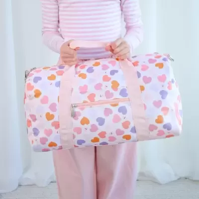 Mala desportiva branca com padrão de corações coloridos e pegas cor-de-rosa