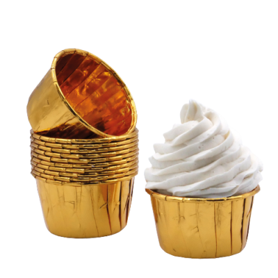 Forminhas douradas para bolinhos, uma com creme branco estilo chantilly