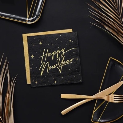 Guardanapo preto com texto dourado 'Happy New Year' junto a talheres dourados e prato preto com detalhes dourados