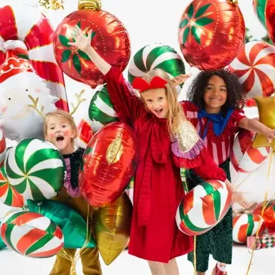 Crianças festivas entre balões metalizados coloridos