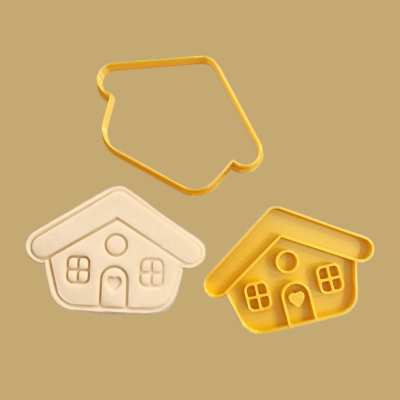 Cortante de massa e peças moldadas em forma de casa em tons amarelo e branco