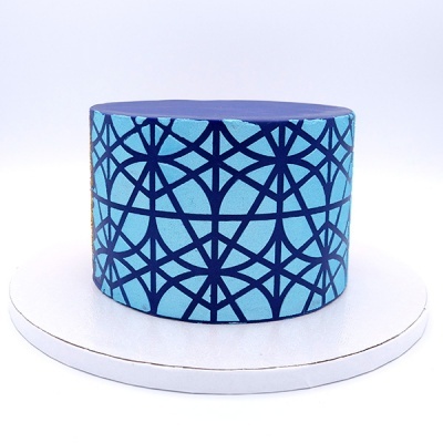Bolo decorado com padrão geométrico azul e base branca