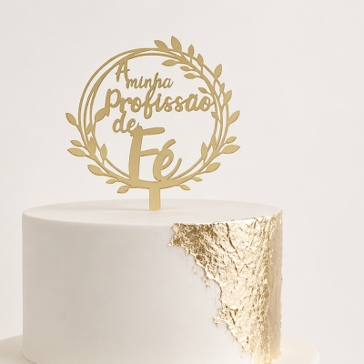 Bolo branco de duas camadas com decoração dourada e enfeite dourado no topo com texto