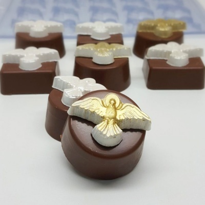 Chocolates redondos e quadrados com decoração de pomba dourada e branca