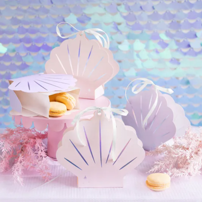 Caixas de concha do mar rosa claro com macarons amarelos e fundo de escamas azuis