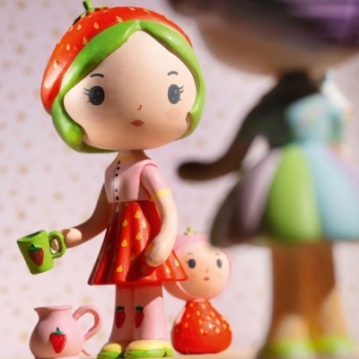 Boneca estilizada com padrão de morangos e acessórios verdes e vermelhos
