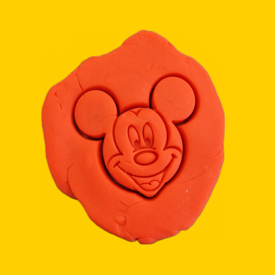 Rosto de Mickey Mouse em argila vermelha sobre fundo amarelo