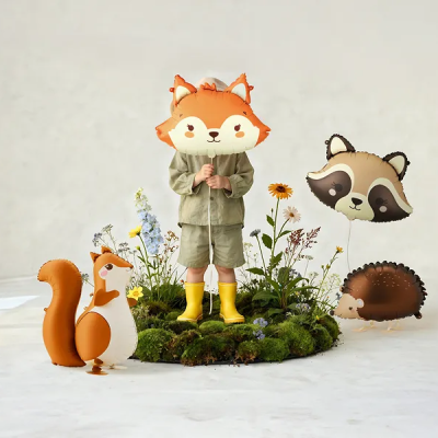 Criança com balões de animais cartoon em musgo e flores