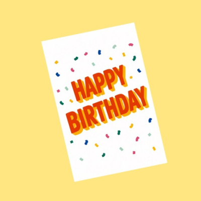 Cartão branco com texto HAPPY BIRTHDAY e confetes coloridos sobre fundo amarelo