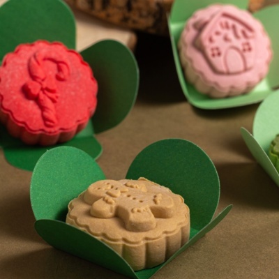 Bolinhos decorados em embalagens verdes sobre superfície castanha