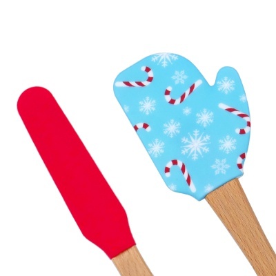 Duas espátulas de cozinha com cabos de madeira, uma vermelha e outra azul com padrões natalícios