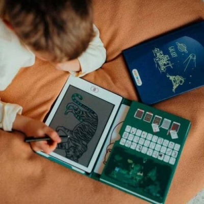 Criança desenhando tigre num ecrã digital com teclado e capa azul com o texto GALAXY