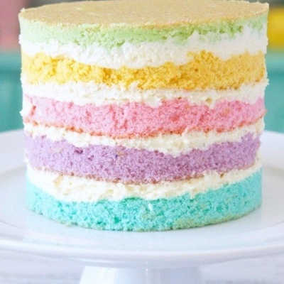Bolo em camadas coloridas em tons pastel com creme branco