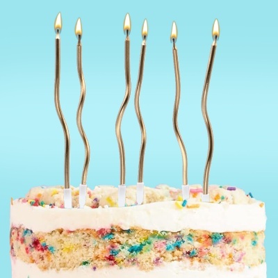 Fatia de bolo com velas douradas acesas