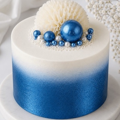 Bolo redondo azul e branco com decoração de pérolas e esfera texturizada no topo