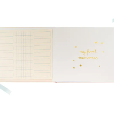 Livro de memórias com capa branca, fita azul clara e texto dourado