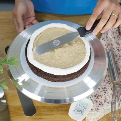 Bolo redondo de chocolate com creme em base metálica giratória