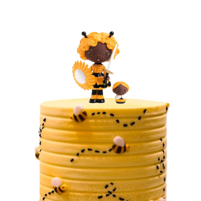 Bolo amarelo decorado com abelhas e figuras de bonecos com roupa preta e amarela no topo