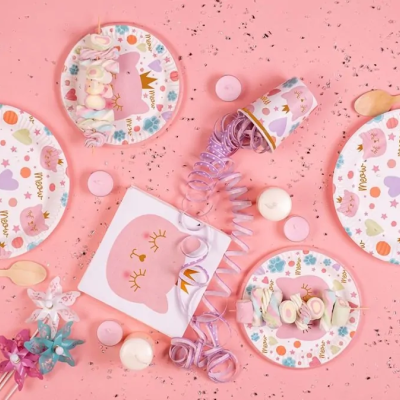 Artigos de festa com padrão de unicórnio e corações sobre fundo rosa