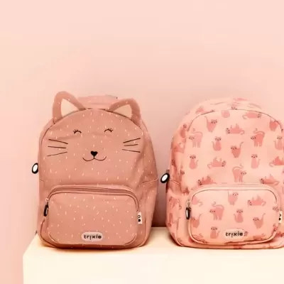Duas mochilas infantis rosas com desenhos de gatos, uma com orelhas e rosto bordado, outra com padrão repetido de gatos.