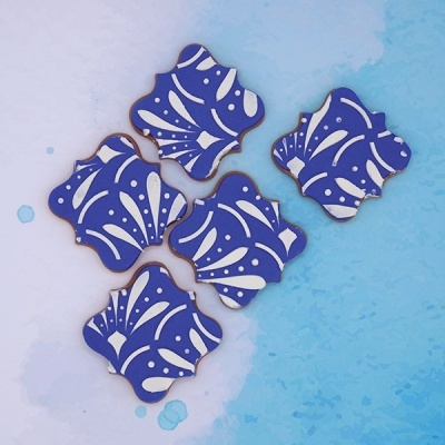 Biscoitos decorados azuis com padrão branco em fundo azul claro