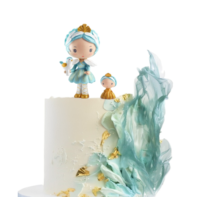 Bolo branco decorado com figuras azuis e douradas e ornamentos translúcidos azuis