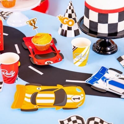 Mesa decorada para festa com tema corrida com pratos, copos, chapéu e bolo quadriculado.