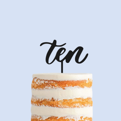 Bolo com cobertura branca e topper preto com a palavra 'ten'