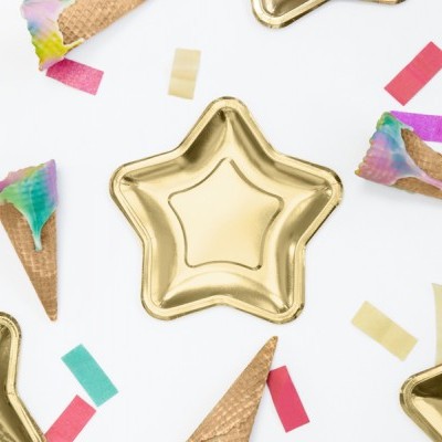 Pratos estrela dourados com cones de gelado coloridos e confetes sobre fundo branco