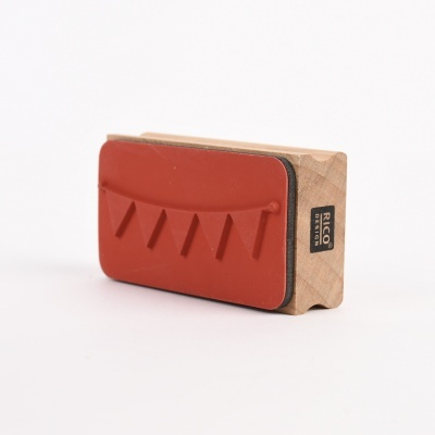 Bloco de madeira com superfície vermelha e etiqueta 'RICO DESIGN'