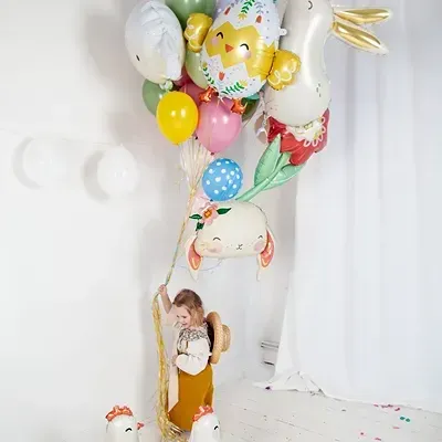 Balões coloridos com temas de Páscoa em sala clara