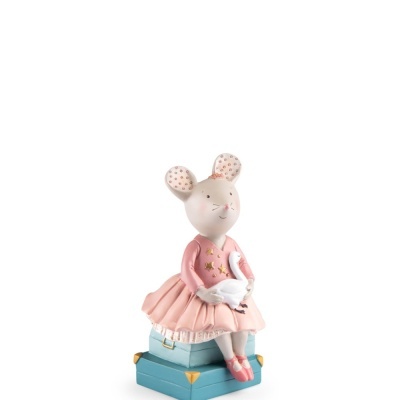 Figurinha decorativa de menina rato com vestido cor-de-rosa sentada em malas azuis