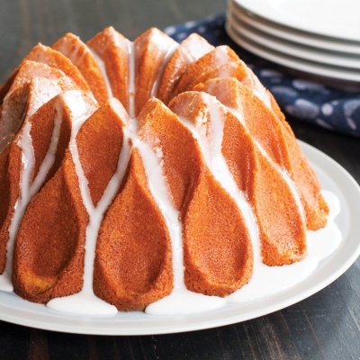 Bolo de bundt com cobertura branca servido num prato branco