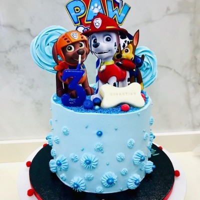 Bolo azul decorado com personagem Paw Patrol e flores de açúcar