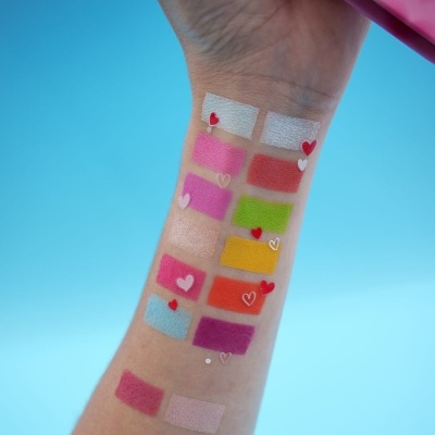 Amostras de maquilhagem coloridas aplicadas num braço com pequenos corações decorativos