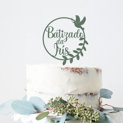 Bolo decorado branco com folhas verdes e placa 'Batizado da Iris' no topo