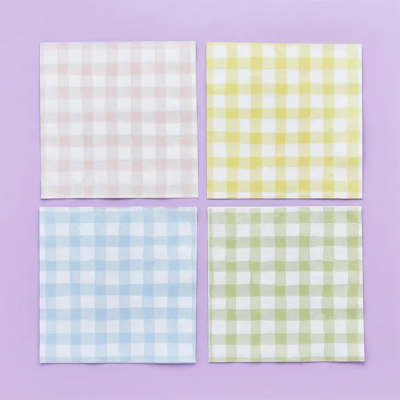 Quatro guardanapos quadrados com padrão xadrez em quatro cores diferentes, sobre fundo lilás.
