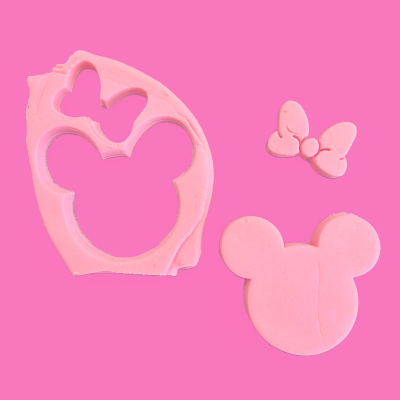 Moldes cor-de-rosa para cabeça de rato e laço sobre fundo cor-de-rosa