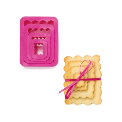 Moldes de silicone rosa e bolachas amarelas empilhadas com fita rosa