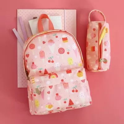 Mochila cor-de-rosa com padrão de gelados e frutas e estojo cor-de-rosa com padrão similar sobre fundo rosa