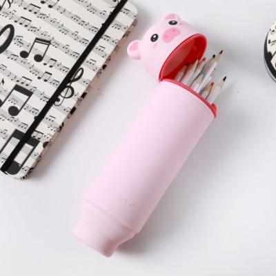 Estojo rosa em forma de porco com lápis coloridos e caderno com pauta musical