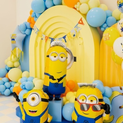 Decoração de festa com balões amarelos, azuis e laranja e personagens Minions