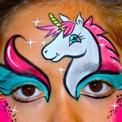 Rosto com pintura facial de unicórnio colorido e detalhes brilhantes