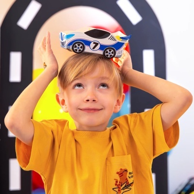 Criança com carrinho de brinquedo na cabeça e t-shirt amarela