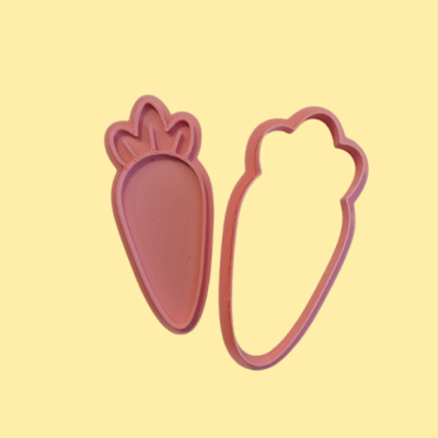 Cortadores de biscoito rosa em formato de cenoura sobre fundo amarelo