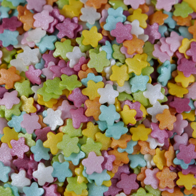 Confeitos açucarados em forma de pequenas flores coloridas e brilhantes