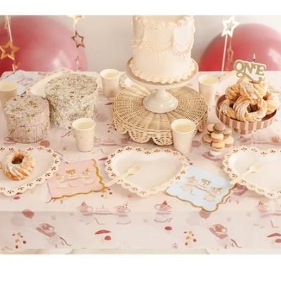 Mesa de festa com decoração em tons pastel, pratos em coração, cupcakes, bolo e balões cor-de-rosa