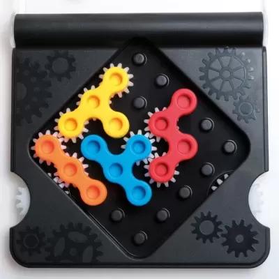 Jogo de tabuleiro com peças coloridas e tabuleiro preto com padrões de engrenagens