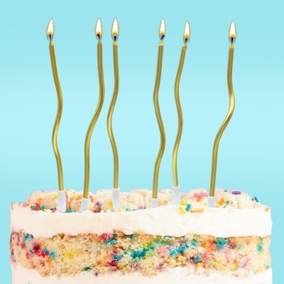 Bolo decorado com velas douradas acesas em fundo azul claro