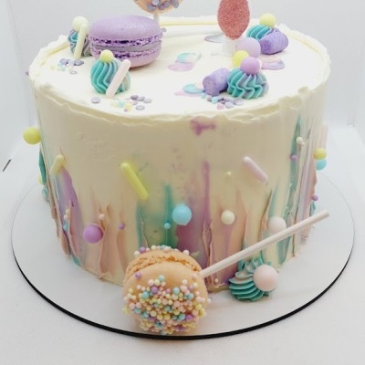 Bolo decorado branco com macarons e topo número 7.